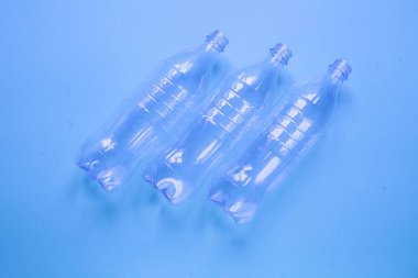 Mavi arka planda üç plastik şişe.