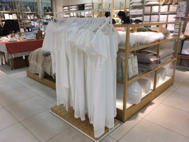 Sıfır kirlilik ve çevre dostu yaşam tarzı akut sosyal sorunlar kavramı. Beyaz organik pamuklu gecelikler mağazada asılı duruyor. Sorumlu moda.