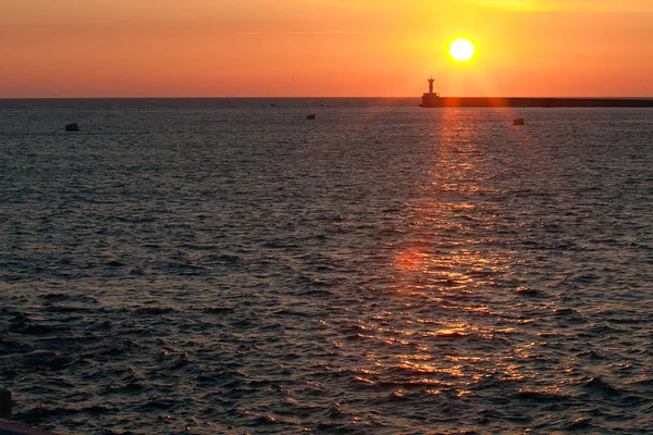 Leuchtturm bei Sonnenuntergang im Meer — Stockfoto