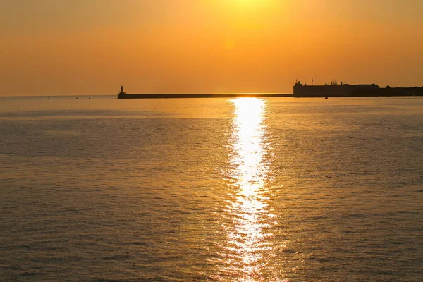 Atardecer naranja sobre el océano negro — Foto de Stock