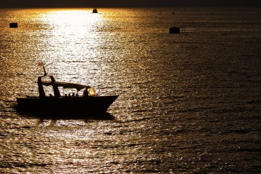Yalnız tekne günbatımında denizde yüzen