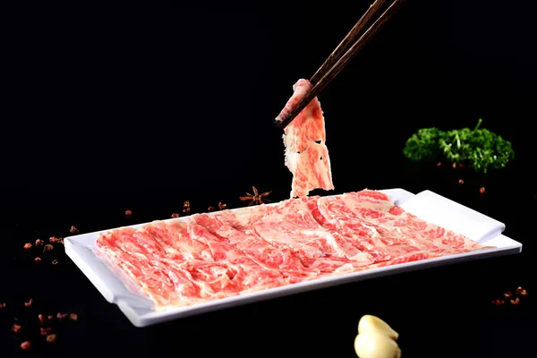 Fresh fat beef slices with a white dish
