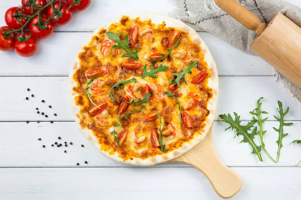 Big shrimp pizza in a wooden pan