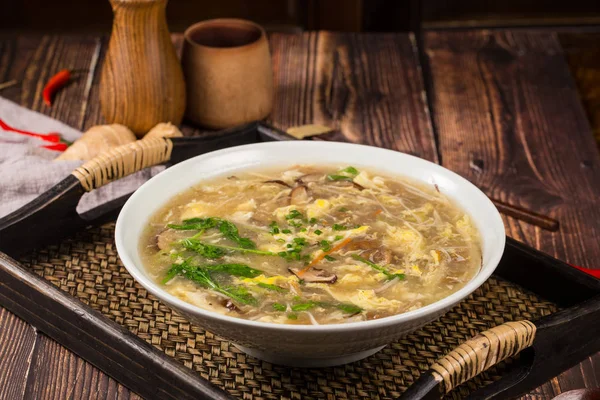 Stewed sugar water with bean curd and mushroom in a white ceramic dish