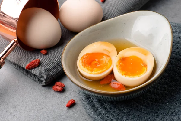 Cut the soft-boiled egg in half in a white ceramic dish