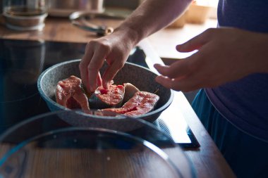 Bir adam balık pişirir.