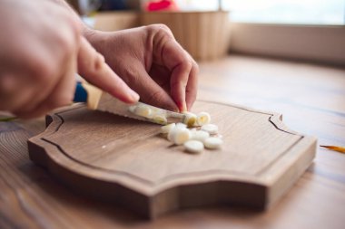 Mutfakta bir adam soğan doğruyor.