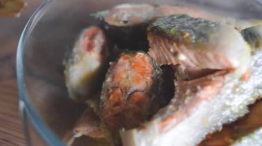 Bir adam balık pişirir.