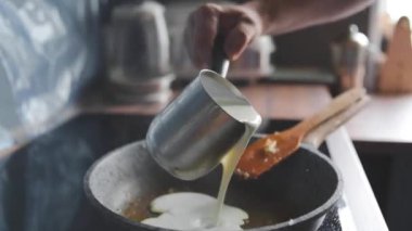 Bir adam krema sosu hazırlar.