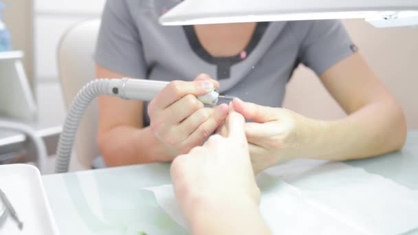 Una manicurista sierra clavos de un hombre — Vídeos de Stock