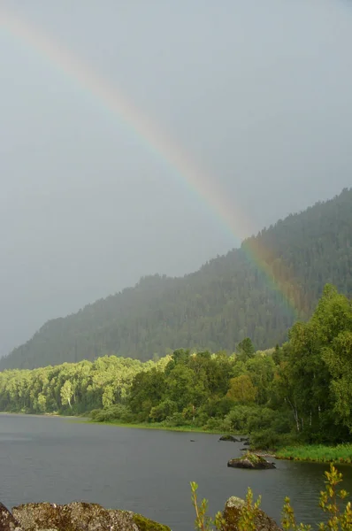 Rainbow after rain in the mountains by the river