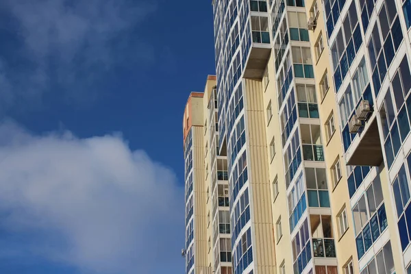 Yeni bina cephe mavi gökyüzüne karşı Windows ile rahat kentsel çok katlı modern yüksek katlı konut yapı