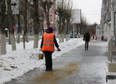 Şehrin insanlar kapıcı işçi serpin kaygan sokaklarda şehir kış buz karşı kum ile hizmet