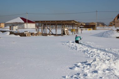 Rusya, Novosibirsk, Mart 8, 2015: bir kadın eve karda bir geçit kazma sürüklenir gizlice