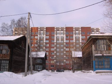 Novosibirsk tarihi binalarda kışın modern bir çok katlı binaya şehirde eski ahşap evler arasında karla kaplı geçit