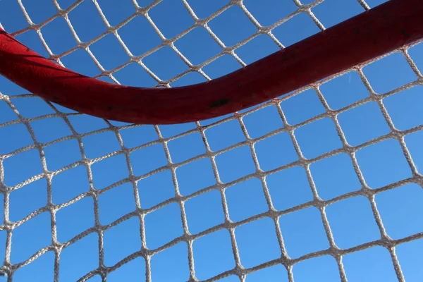 football net stretched on a sports frame hockey goal against the sky