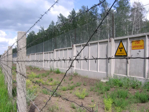 Valla de hormigón gris en instalaciones de residuos radiactivos peligrosos con — Foto de Stock