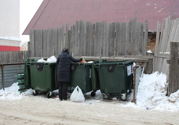 Rusya, Novosibirsk, Şubat 23, 2019: çöp tenekeleri hurda ve çöp sosyal sorun arayan kötü giyimli işsiz kadın emekli