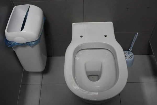 Білий туалет з гігієнічним відром у громадському туалеті санітарна кімната — стокове фото