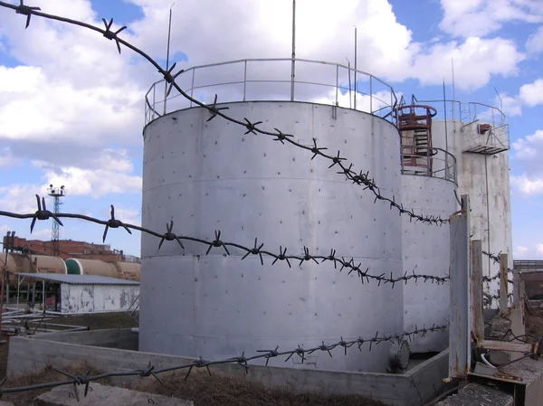 metal tanks storage tank for oil reserves on the territory of the industrial enterprise for barbed wire in the fence