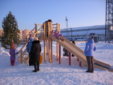 Rusya, Novosibirsk, 15 Ocak 2012: neşeli çocuklar ve aileleri kış yürüyüşünde parka buzdan bir kayakla gidiyorlar.