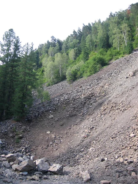 Kayalık bir dağ, kayalardan bir talus vadiye doğru kayıyor. — Stok fotoğraf