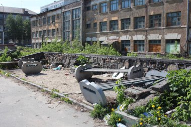 Rusya, Novosibirsk, 15.05.2020: evin yakınındaki yıkık yolda çöp yığını olan kirli bir sokaktaki kırık banklar