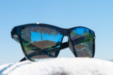 Mavi deniz arka plan üzerinde güneş gözlüğü. Yaz gebeliği. Plaj manzarası. Havlu üzerinde Gözlük