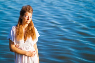 nehir önünde açık duran rahatlatıcı güzel genç kadın 