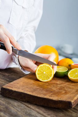 Erkek mutfak ahşap masa üzerinde limon kesme eller