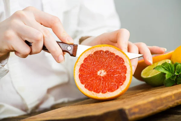 Vrouwelijke Handen Snijden Grapefruit Houten Tafel Keuken Rechtenvrije Stockfoto's