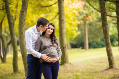  genç hamile çift sonbahar parkta sarılma 