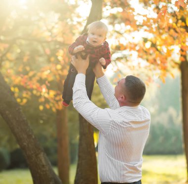 mutlu baba ve oğul birlikte sonbahar parkta eğleniyor 