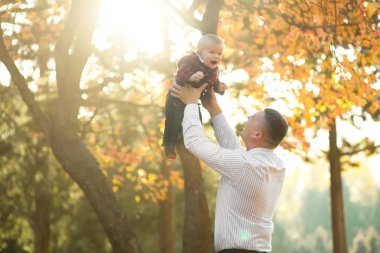 mutlu baba ve oğul birlikte sonbahar parkta eğleniyor 
