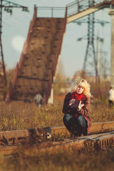 kitap ve on rails, vintage atmosfer oturmuş poz sarışın genç kadın 