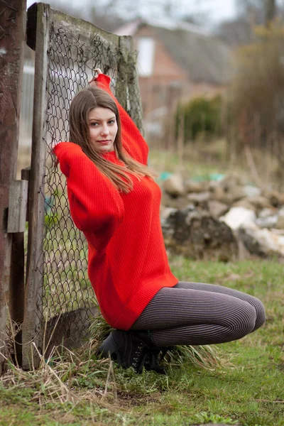 Νεαρή Γυναίκα Κόκκινο Πουλόβερ Θέτοντας Κοντά Τοίχο Από Τούβλα — Φωτογραφία Αρχείου
