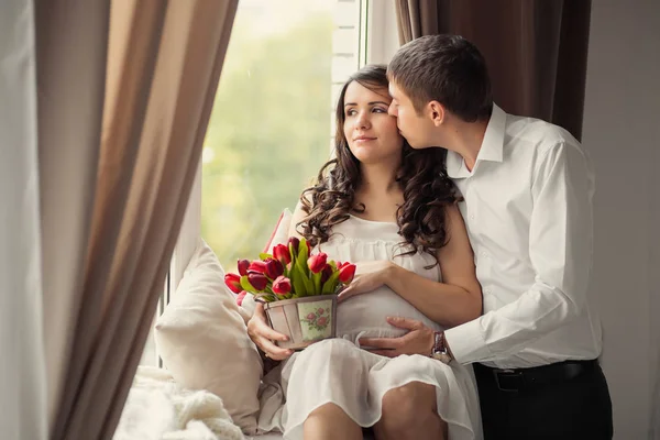 Junge Schwangere Frau Mit Mann Sitzt Fenster Und Küsst — Stockfoto