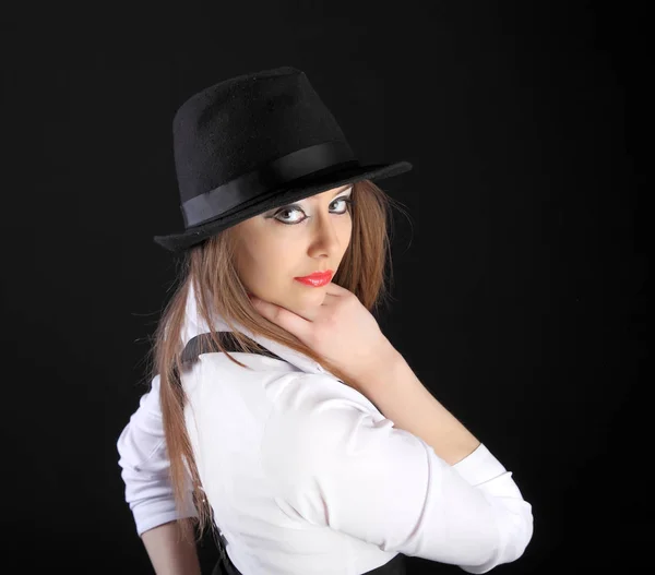 beautiful young woman in hat in studio black background