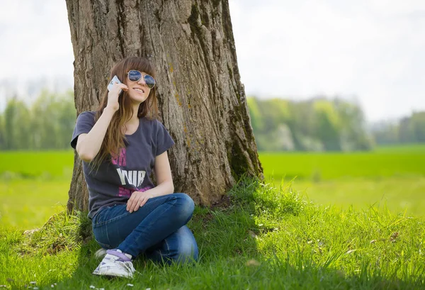 Vrouw Zitten Groene Gras Leunend Boom Praten Mobiele Telefoon — Stockfoto