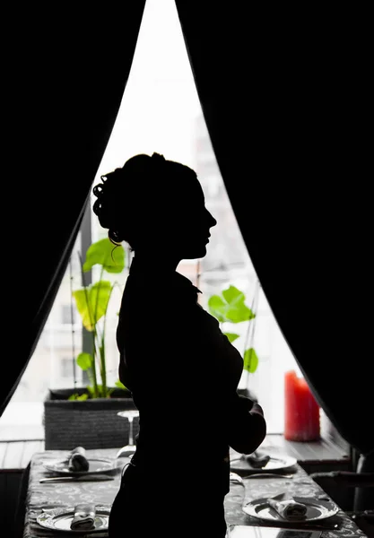Silhouette of a young woman in restaurant
