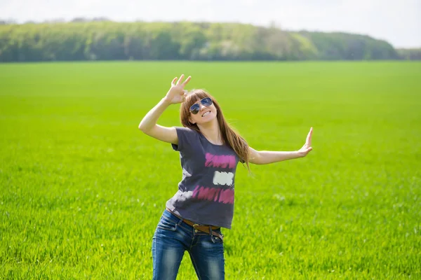 夏の草原の緑の芝生でポーズ美しい若いブルネットの女性 — ストック写真