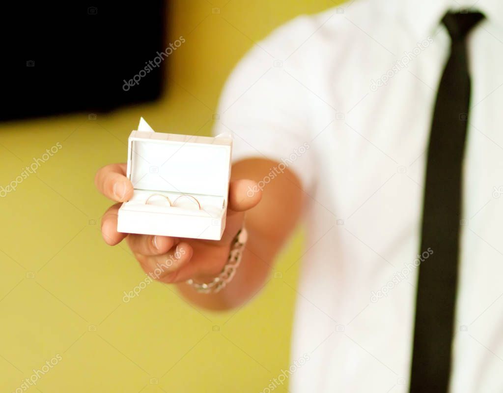 A Man holding a diamond rings in a gesture of giving