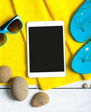 Tablet pc kavramı yaz, flop flip ayakkabı, iskele üzerinde güneş gözlüğü