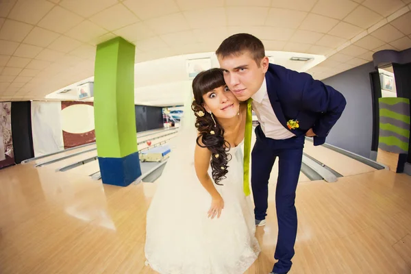 Bröllopsparet med roliga ansikten på bowling parkett — Stockfoto