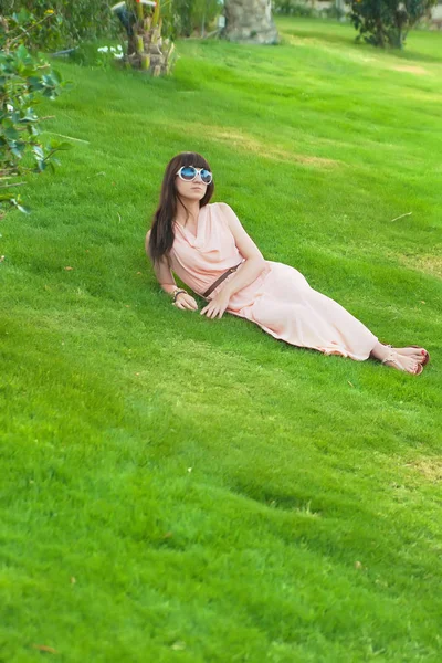 Piękna kobieta, leżąc na podłodze trawa w parku — Zdjęcie stockowe