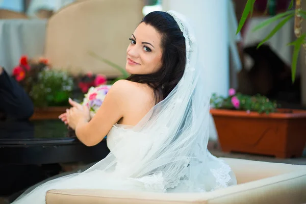 Foto de uma bela noiva morena em um vestido de casamento luxuoso — Fotografia de Stock