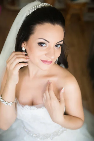 Foto de uma bela noiva morena em um vestido de casamento luxuoso — Fotografia de Stock