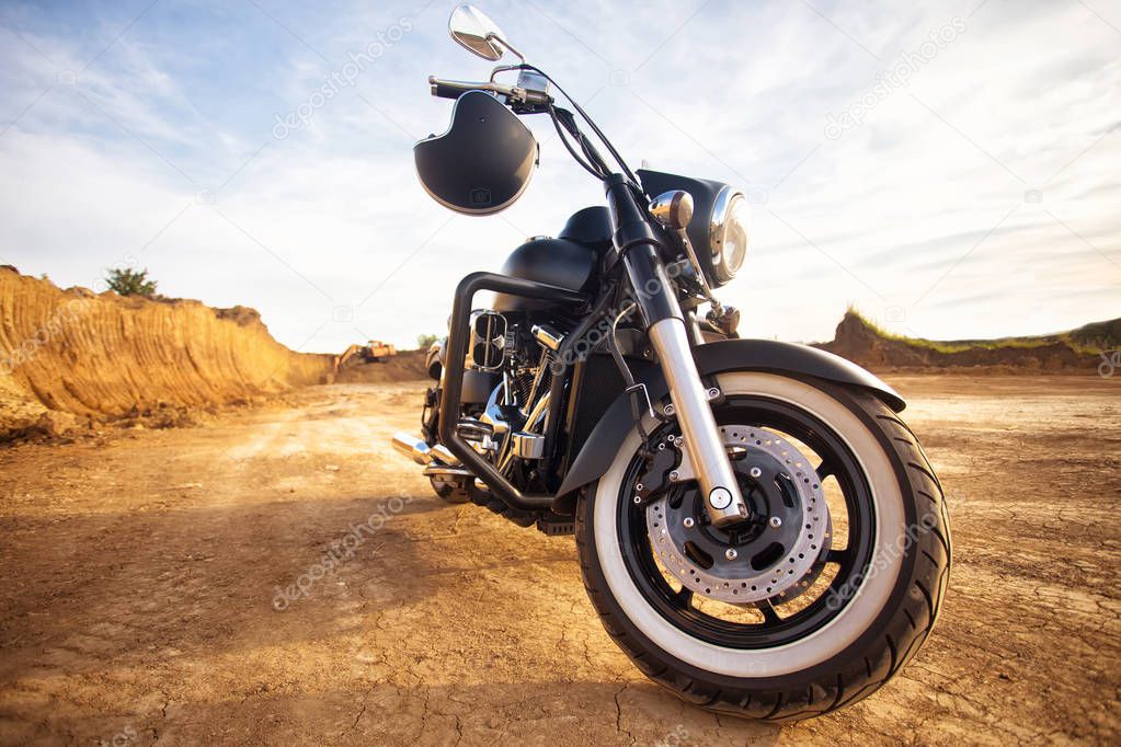 Big, clean, black and unknown chopper bike in desert