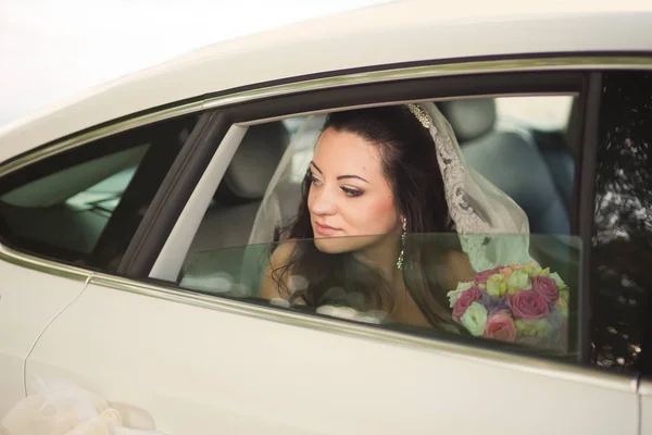 Attractive caucasian bride sitting in car and smile to the camer — Stock Photo, Image