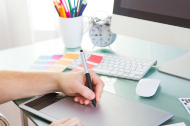 Genç yakışıklı grafik tasarımcı grafik tablet masasında onun işi yapmak için kullanma